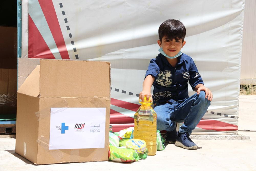 Geflüchteter syrischer Junge mit Nahrungsmittelpaket (Quelle: Kristine Weyland)