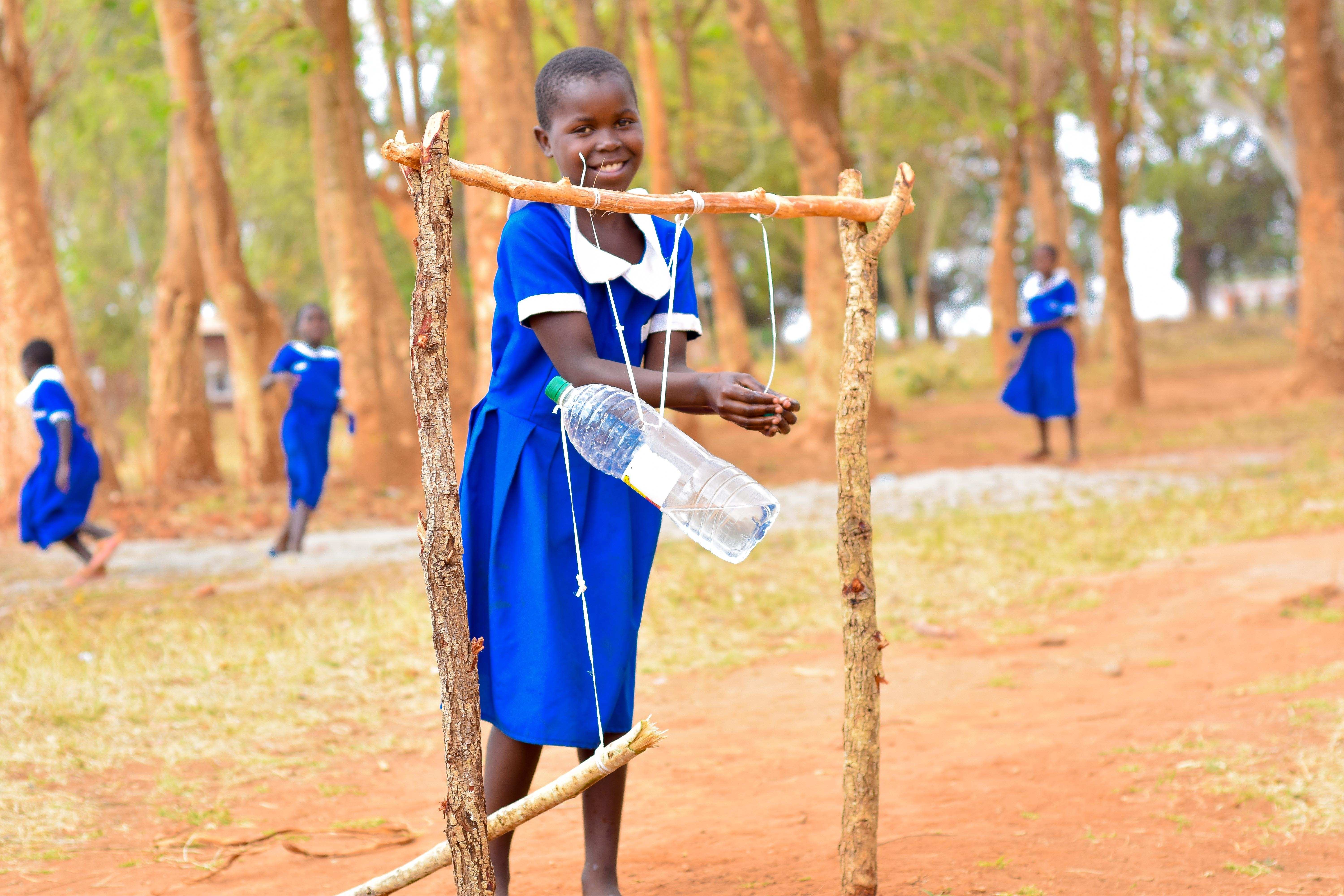BLANDINA LUNGU (SLIP ON SHOES) GIRL IN BLUE UNIFORM WITH CHILDREN PLAYING IN THE BACKGROUND

Projekt LU

10-2021