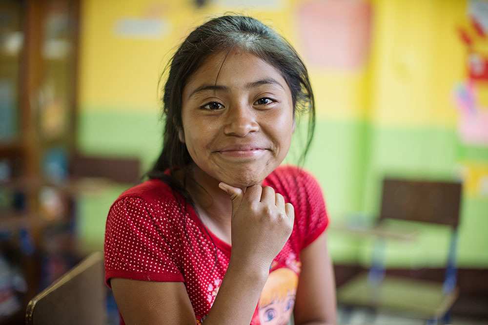 Magdalena strahlt, weil sie endlich in die Schule gehen und lernen kann (Foto: Kindernothilfe)