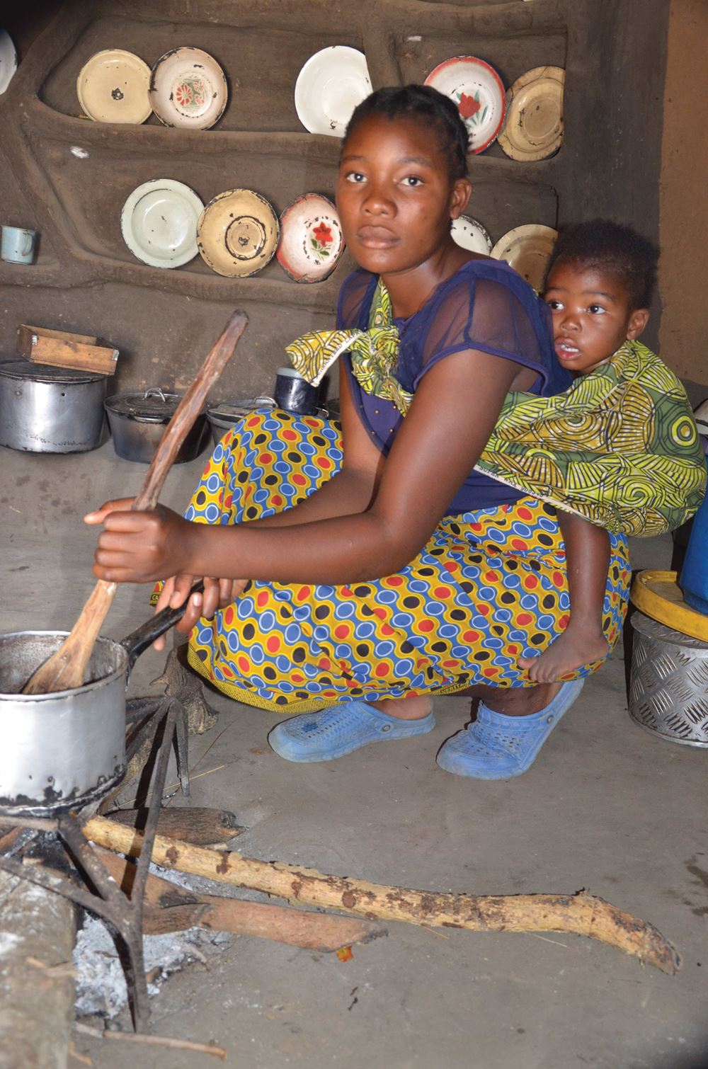 Mädchen mit Baby beim Kochen (Quelle: Kindernothilfe Luxembourg)